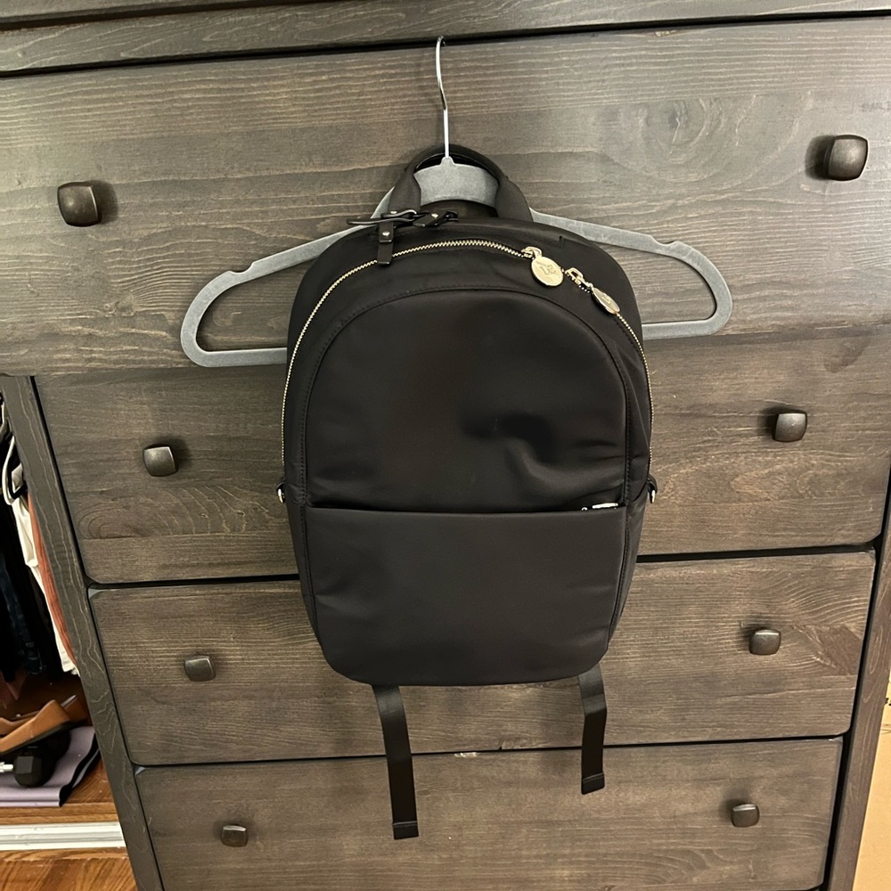 Lo and Sons Beacon backpack. Black with lavender lining. Gold hardware.